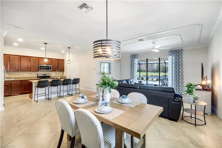 Dining area with baseboards, visible vents, and crown molding