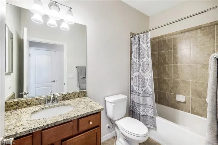 Third Bathroom with vanity, toilet, and shower / bath combo with shower curtain