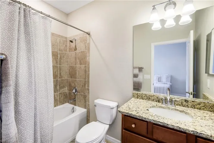 2nd Bathroom featuring vanity, toilet, and shower / bath combo with shower curtain
