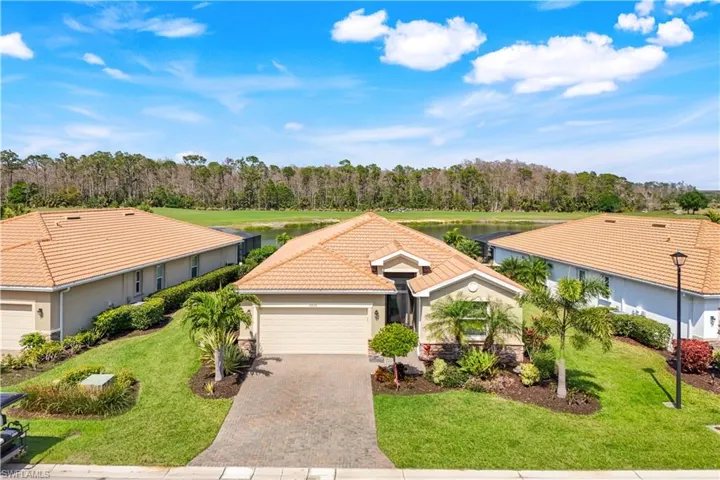 Single story home with decorative driveway, stucco siding, a garage, a tiled roof, and a front lawn