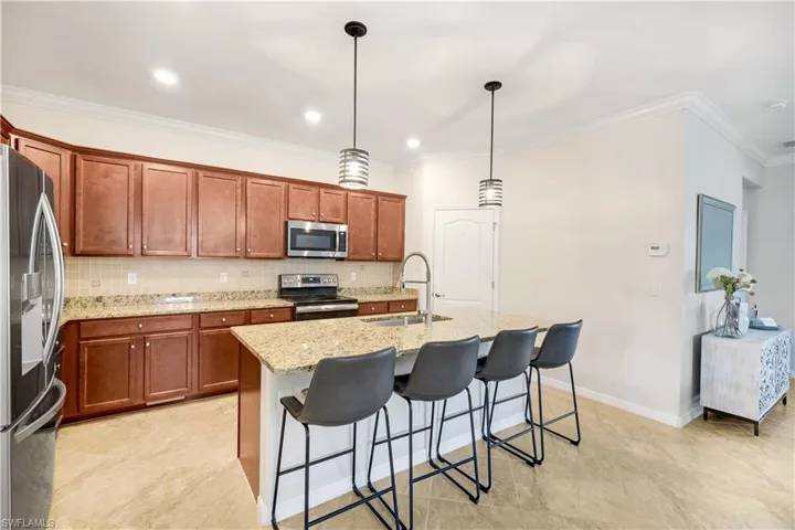 Kitchen with light granite counters, crown molding, stainless steel appliances, tasteful backsplash, and a sink