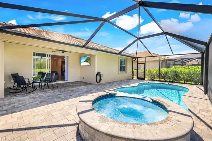 View of pool featuring a lanai, a pool with connected hot tub, a ceiling fan, and a patio