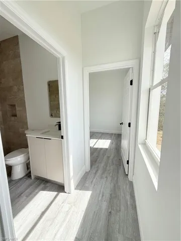 Bathroom with vanity, hardwood / wood-style floors, and toilet