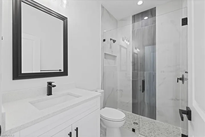Bathroom featuring a modern shower, vanity, and recessed lighting