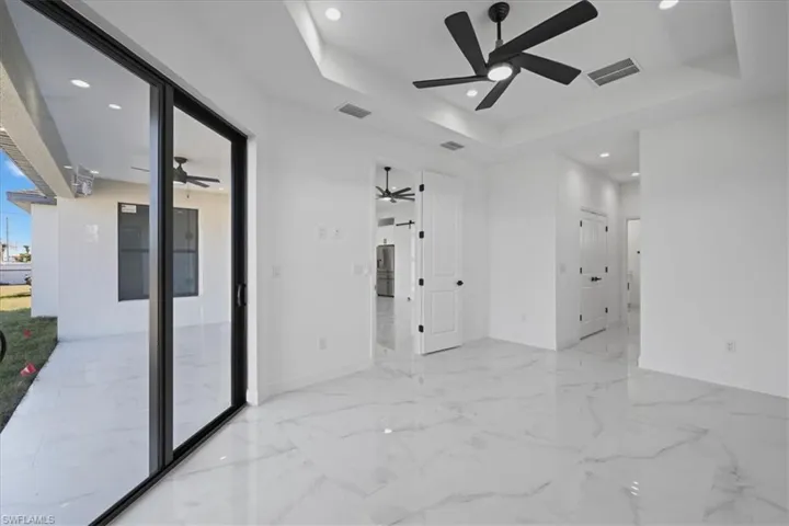 Empty primary room featuring recessed lighting, a raised ceiling, and a ceiling fan