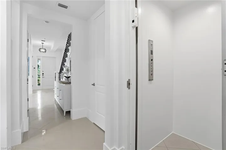 Corridor with light tile patterned flooring and elevator