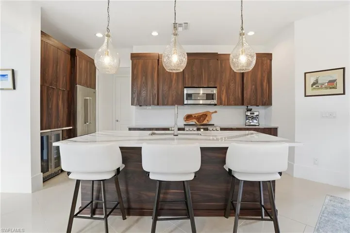 Kitchen featuring a breakfast bar area, modern cabinets, and light stone countertops