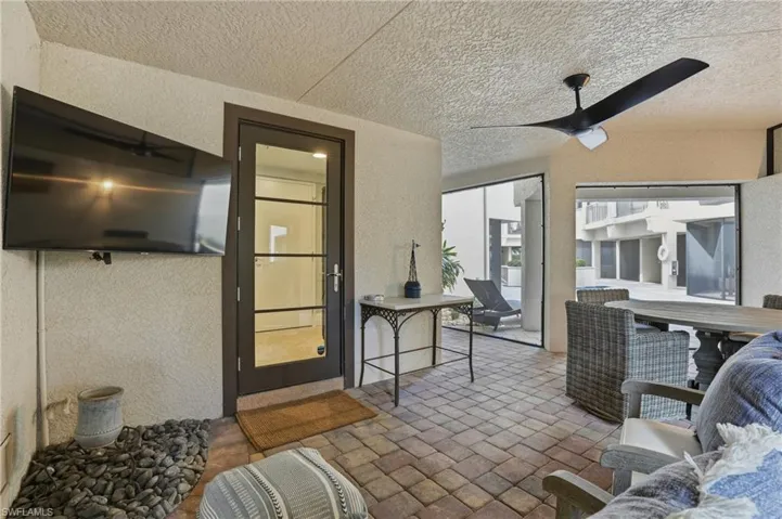 Sunroom featuring ceiling fan, outdoor dining area, and a patio
