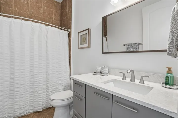 Bathroom with a shower with curtain and vanity