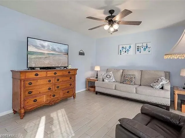 Living room with ceiling fan and light wood finished floors