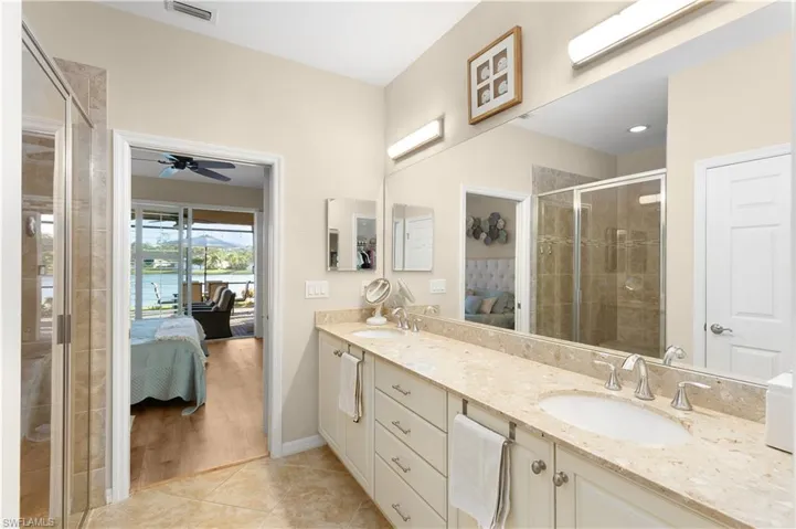 Bathroom with ceiling fan, a shower with door, vanity, and wood-type flooring