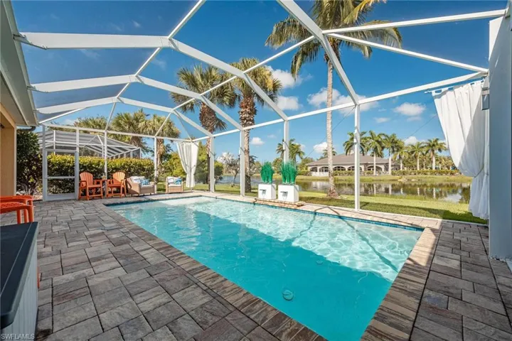View of swimming pool with a patio area and a lanai