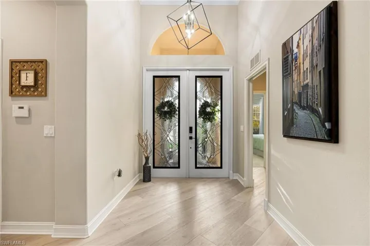 Foyer entrance with an inviting chandelier and French doors