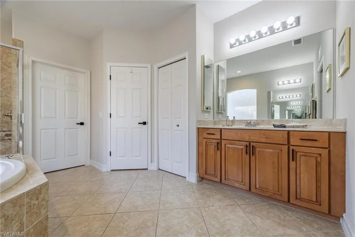 Owners bathroom featuring walk in shower, vanity