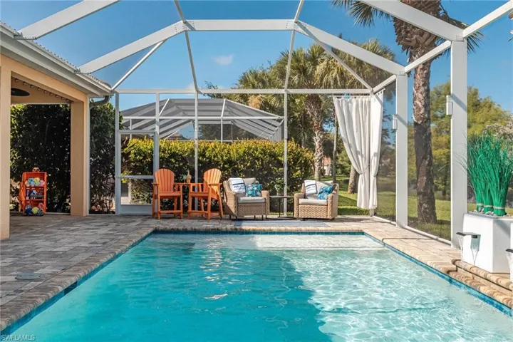 View of pool with a patio and glass enclosure