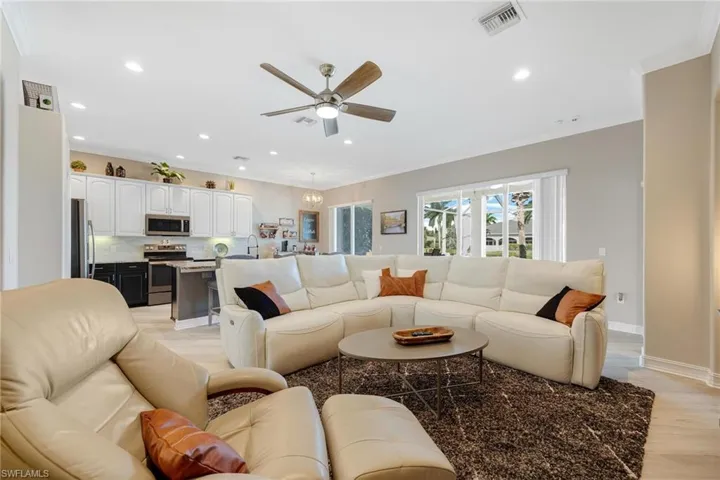 Living room featuring ceiling fan and crown molding