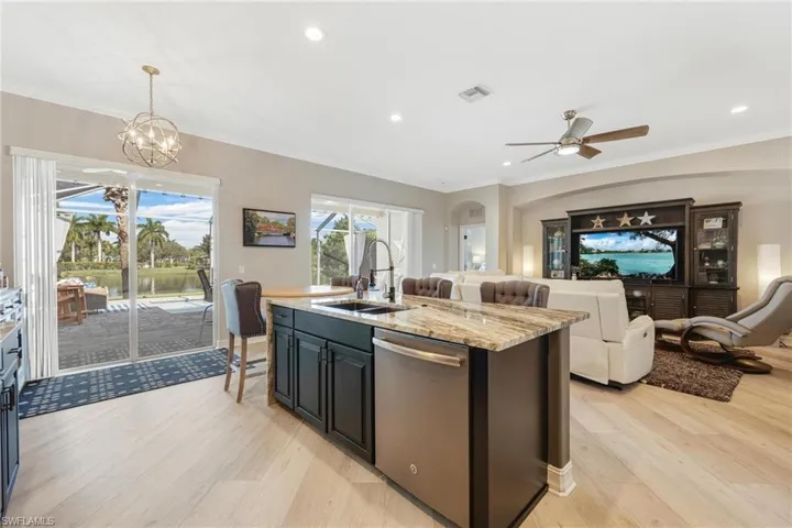 Kitchen with notable chandelier, light stone countertops