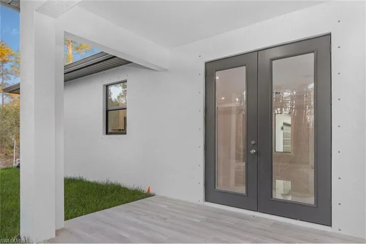 Doorway to property featuring french doors and stucco siding
