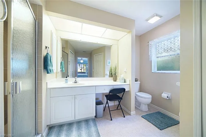 Primary Bathroom with a shower and vanity sitting area.