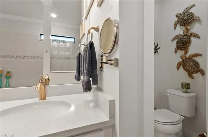 Bathroom featuring vanity, ornamental molding, and a tile shower