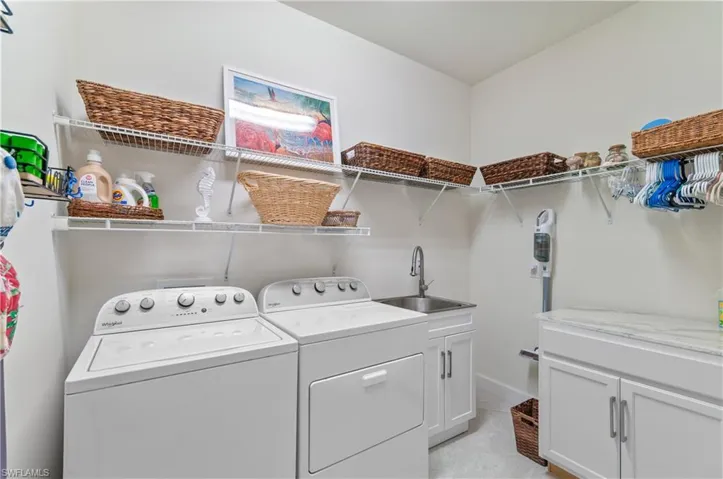 Laundry area featuring washer and clothes dryer and cabinet space