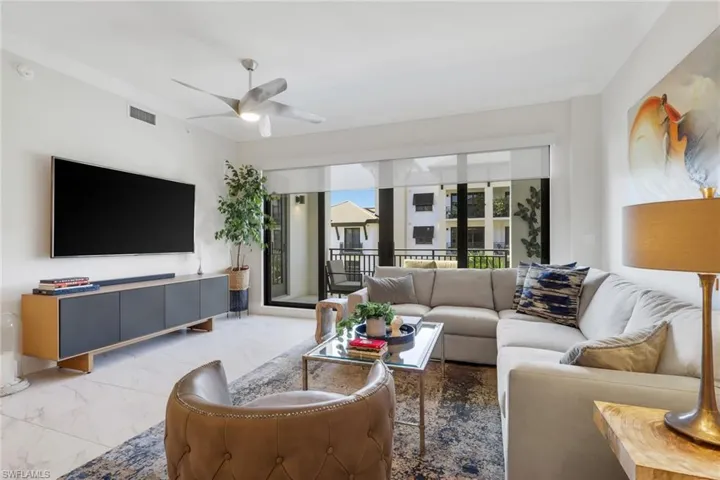 Living area with marble look tile flooring, a ceiling fan, and french doors