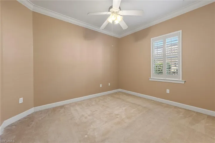 Guest bedroom with ceiling fan, carpet floors, mounted TV and crown molding