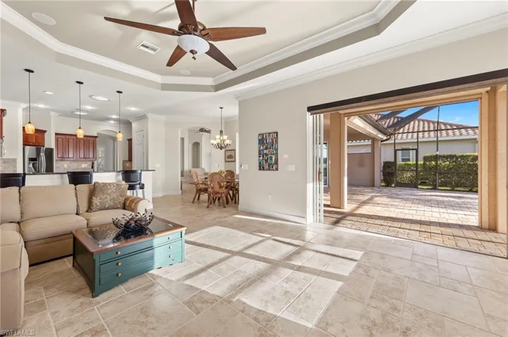 Living room with light tile floors, crown molding and ceiling fan