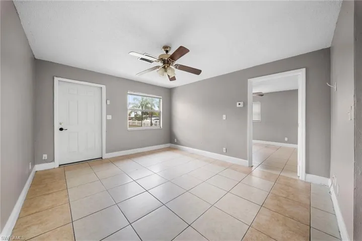 Unfurnished room featuring ceiling fan, a textured ceiling, and light tile patterned flooring