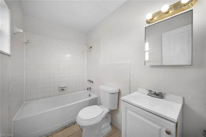 Bathroom featuring vanity, shower / washtub combination, and light tile patterned floors