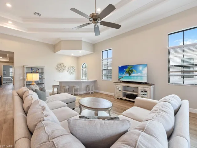 Living room with ceiling fan, ornamental molding, and light hardwood / wood-style flooring