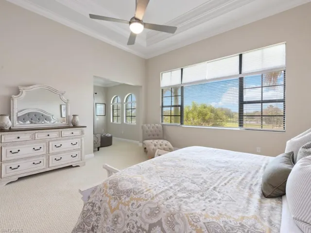 Bedroom featuring ceiling fan, light carpet, and ornamental molding