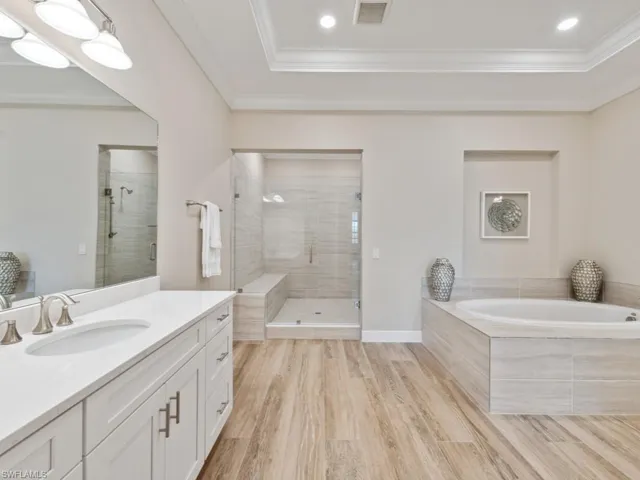 Bathroom with plus walk in shower, soaking tub, vanity, wood-style tile flooring, and crown molding