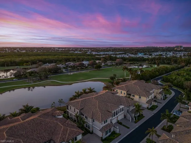 Aerial view at dusk featuring a water & golf course view