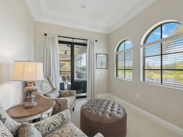 Sitting room in Primary Bedroom with carpet and crown molding