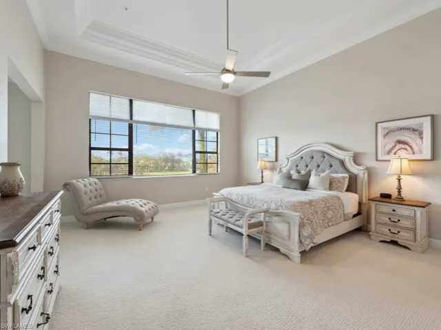 Luxury carpeted bedroom with ceiling fan and ornamental molding