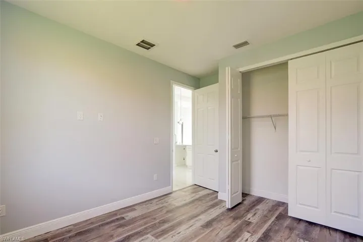 Unfurnished bedroom with wood finished floors and a closet