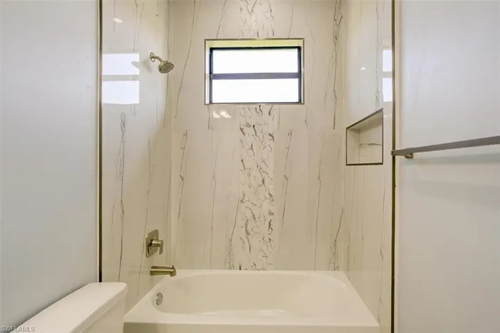 Bathroom with bathing tub / shower combination and toilet