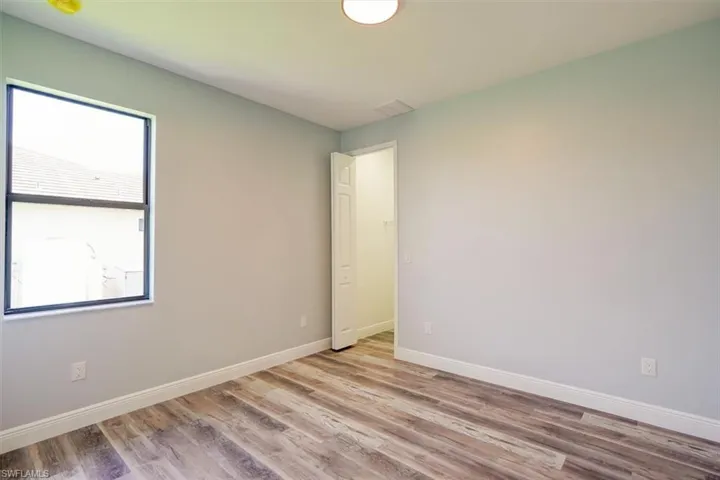 Unfurnished room featuring light wood finished floors and baseboards