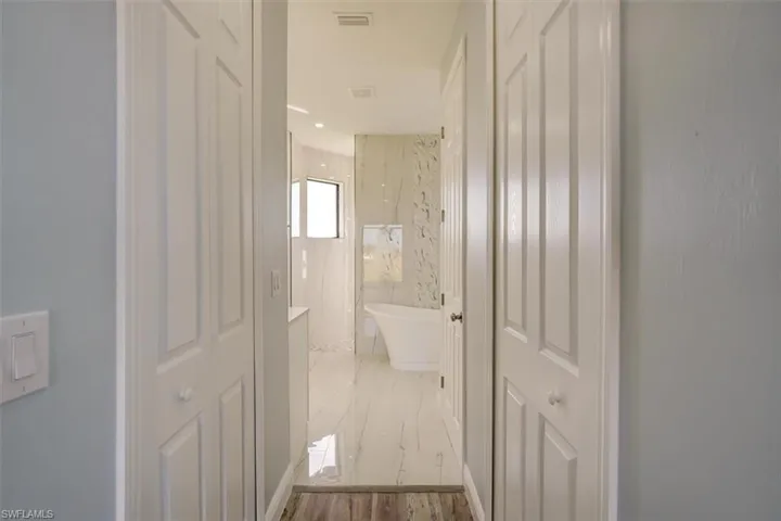Full bath featuring a freestanding tub, a marble finish shower, and recessed lighting