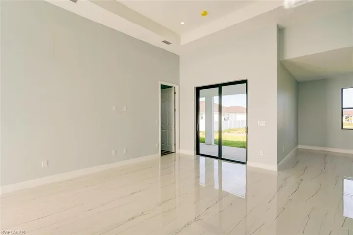 Spare room with a high ceiling, recessed lighting, and light marble finish flooring