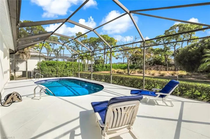 Swimming pool featuring a sunroom, a patio area, and glass enclosure