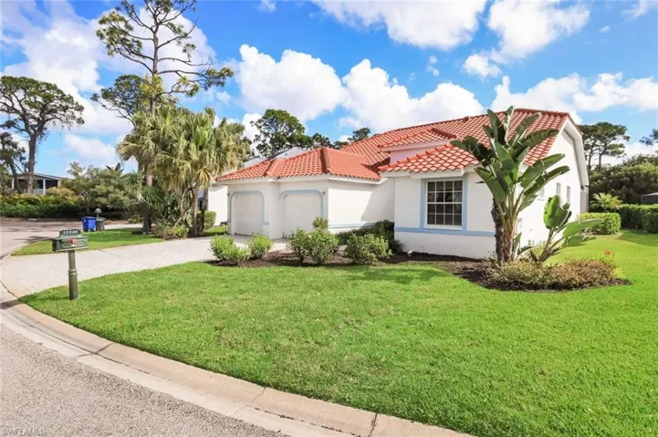 Mediterranean / spanish-style home with a garage, stucco siding, a front yard, driveway, and a tiled roof