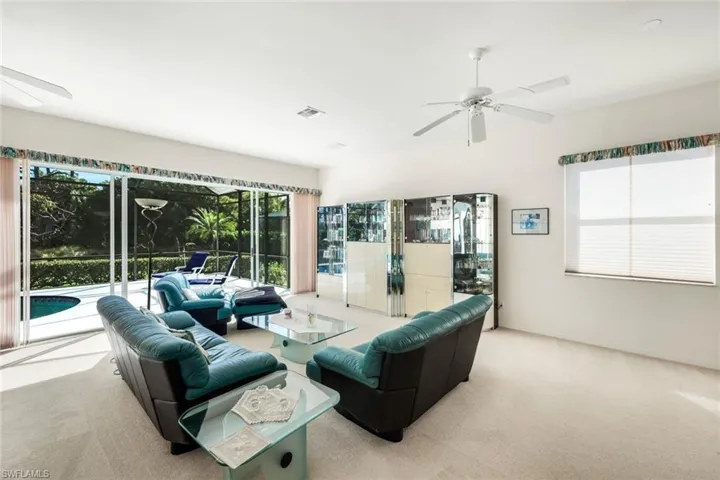 Living area featuring ceiling fan, a sunroom, and light colored carpet