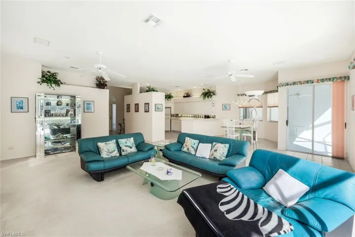Living area featuring ceiling fan and light colored carpet