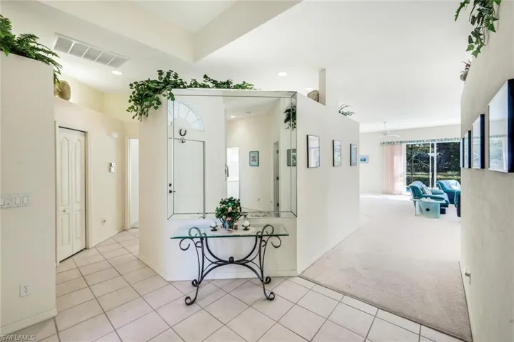 Hallway featuring light carpet, light tile patterned floors, and recessed lighting