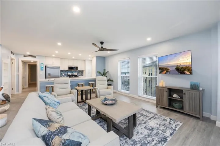 Living area with light wood-style flooring, recessed lighting, and a ceiling fan