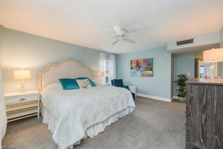 Bedroom with light carpet and a ceiling fan