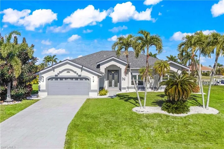 Ranch-style house with a front lawn, driveway, an attached garage, and stucco siding