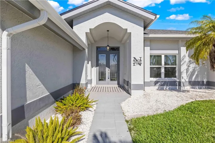 Entrance to property featuring stucco siding and french doors